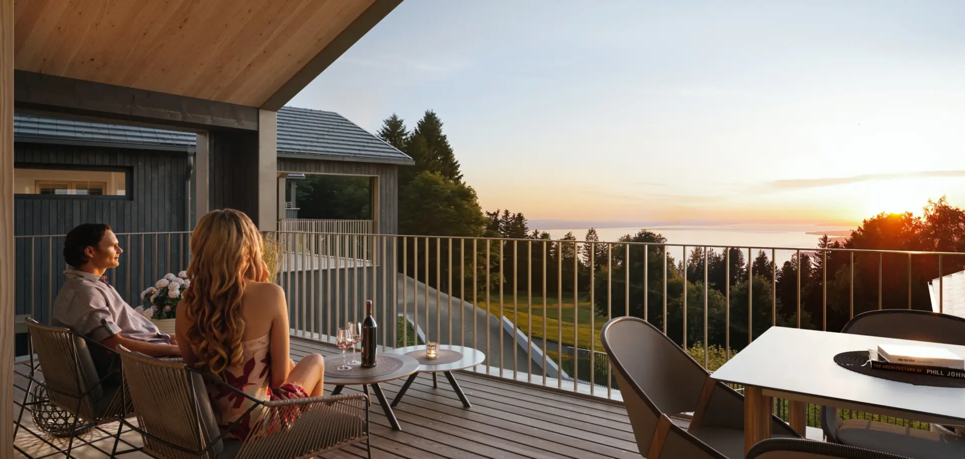 Paar auf der Terrasse eines SEEnsucht BERGchalets am Pfänder bei Sonnenuntergang mit Blick auf den Bodensee